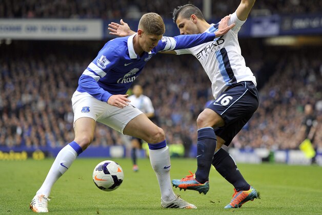 Everton's John Stones left, and Manchester City's Sergio Aguero battle for the ball during their English Premier League soccer match at Goodison Park in Liverpool, England, Saturday May 3, 2014. (AP Photo/Clint Hughes)