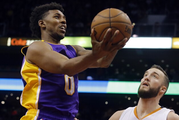 Los Angeles Lakers forward Nick Young (0) drives on Phoenix Suns center Miles Plumlee (22) in the first quarter during an NBA basketball game, Monday, Jan. 19, 2015, in Phoenix. (AP Photo/Rick Scuteri)
