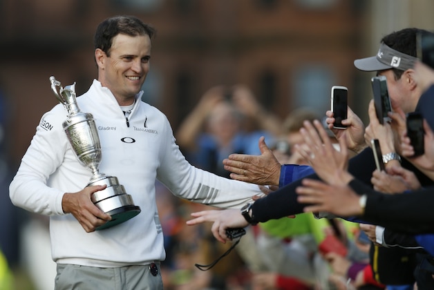 United States’ Zach Johnson celebrates with members of the public as he holds the trophy after winning a playoff after the final round at the British Open Golf Championship at the Old Course, St. Andrews, Scotland, Monday, July 20, 2015.(AP Photo/Jon Super)