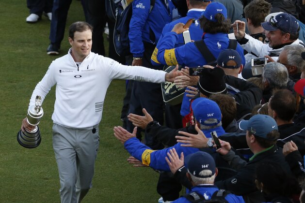 United States’ Zach Johnson celebrates with members of the public as he holds the trophy after winning a playoff after the final round at the British Open Golf Championship at the Old Course, St. Andrews, Scotland, Monday, July 20, 2015. (AP Photo/Alastair Grant)