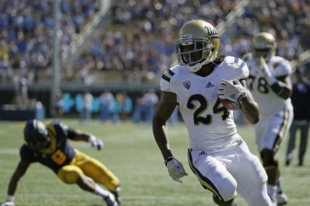UCLA running back Paul Perkins runs with the ball for a touchdown as California linebacker Jason Gibson, left, looks on during the first quarter of a NCAA college football game Saturday, Oct. 18, 2014, in Berkeley, Calif. At right is UCLA offensive lineman Malcolm Bunche. (AP Photo/Eric Risberg)