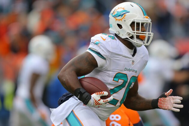 DENVER, CO - NOVEMBER 23:  Running back Lamar Miller #26 of the Miami Dolphins rushes against the Denver Broncos during a game at Sports Authority Field at Mile High on November 23, 2014 in Denver, Colorado.  (Photo by Justin Edmonds/Getty Images)