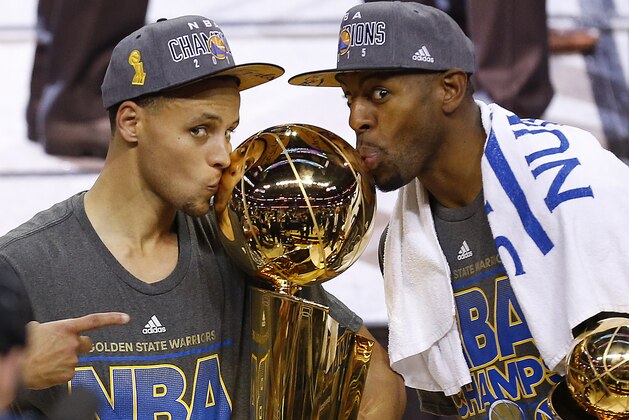 Golden State Warriors Stephen Curry, left, and Andre Iguodala celebrate with the Larry O'Brien Trophy after Game 6 of basketball's NBA Finals in Cleveland, Wednesday, June 17, 2015. The Warriors defeated the Cleveland Cavaliers 105-97 to win the best-of-seven game series 4-2. (AP Photo/Paul Sancya)