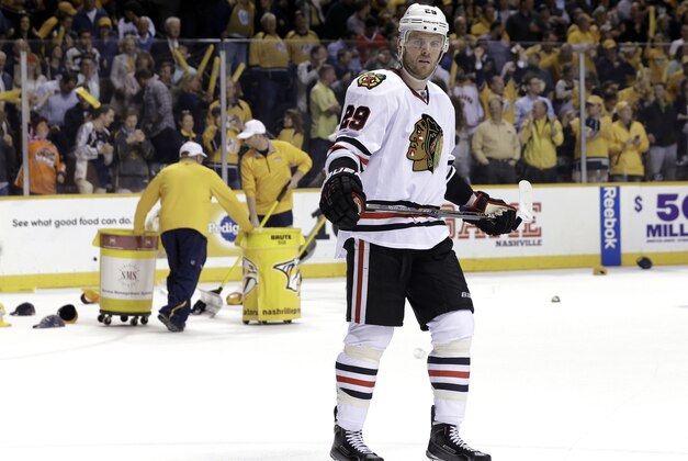 Chicago Blackhawks left wing Bryan Bickell skates around the rink as a crew cleans up hats thrown on the ice after Nashville Predators center Filip Forsberg, of Sweden, scored a hat trick in the third period of Game 5 of an NHL hockey first-round playoff series Thursday, April 23, 2015, in Nashville, Tenn. The Predators won 5-2. The Blackhawks lead the series 3-2. (AP Photo/Mark Humphrey)