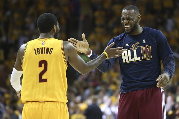 En esta foto del martes 26 de mayo de 2015, Kyrie Irving, de los Cavaliers de Cleveland, intercambia una palmada con su compañero LeBron James durante una pausa en el cuarto encuentro de la final de la Conferencia del ESte, ante los Hawks de Atlanta (AP Foto/Ron Schwane, archivo)