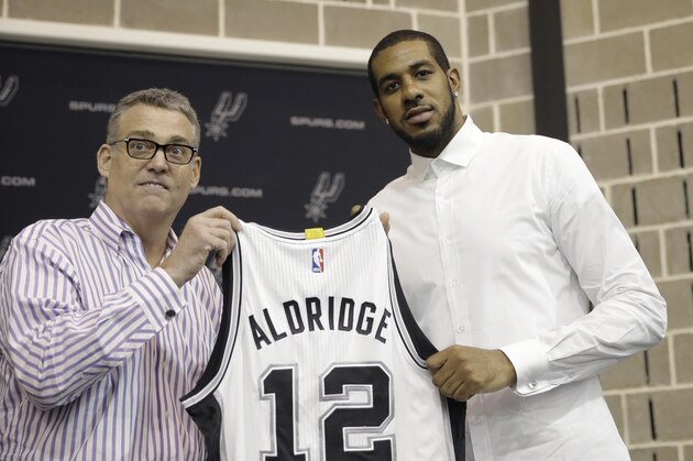 LaMarcus Aldridge, right, poses with San Antonio Spurs general manager R.C. Buford, left, and his new jersey during a news conference at the team's practice facility as he is formally introduced after he signed with the San Antonio Spurs NBA basketball team, Friday, July 10, 2015, in San Antonio. (AP Photo/Eric Gay)