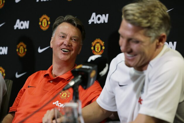 Manchester United manager Louis van Gaal, left, looks on as new signing Bastian Schweinsteiger speaks during a press conference, Wednesday, July 15, 2015, in Bellevue, Wash. Manchester United is in Seattle for an international friendly soccer match against Mexico's Club America to be played on Friday. (AP Photo/Ted S. Warren)