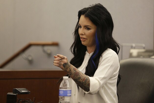 FILE - In this Nov. 14, 2014, file photo, Christine Mackinday, also known as Christy Mack, points toward Jonathan Paul Koppenhaver, also known as War Machine, during a preliminary hearing for Koppenhaver in Las Vegas. A judge on Tuesday, Dec. 2, 2014 revoked probation for Koppenhaver, the former mixed martial arts fighter War Machine on a prior felony conviction while he awaits trial on charges that could get him life without parole for allegedly trying to kill Mackinday, his porn actress ex-girlfriend and her friend. The judge invoked a 1½-to-4 years’ sentence she suspended in Feb. 2012 after Koppenhaver’s guilty plea in a felony attempted battery case. (AP Photo/John Locher)