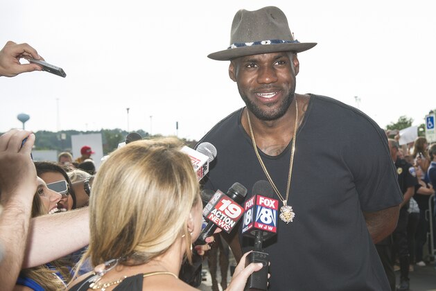 LeBron James talks with reporters as he arrives at the special screening of the comedy,