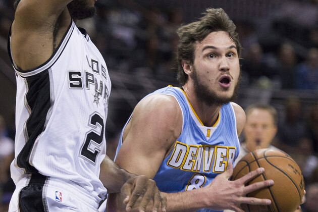 Denver Nuggets forward Danilo Gallinari, right, of Italy, drives around San Antonio Spurs forward Kawhi Leonard during the first half of an NBA basketball game, Friday, April 3, 2015, in San Antonio. (AP Photo/Darren Abate)