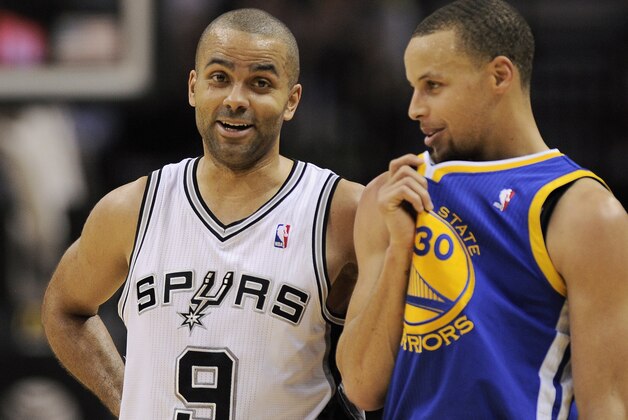 San Antonio Spurs guard Tony Parker, left, of France, talks to Golden State Warriors guard Stephen Curry during the first half of an NBA basketball game on Wednesday, April 2, 2014, in San Antonio. (AP Photo/Darren Abate)