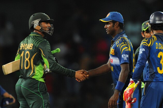Pakistani cricketer Shoaib Malik (L) is congratulated by Sri Lanka captain Angelo Mathews (C) after their victory in the fourth One Day International (ODI) match between Sri Lanka and Pakistan at the R Premadasa International Cricket Stadium in Colombo on July 22, 2015. Pakistan defeated Sri Lanka by seven wickets in the fourth one-day international in Colombo on Wednesday to take a decisive 3-1 lead in the five-match series. AFP PHOTO / LAKRUWAN WANNIARACHCHI        (Photo credit should read LAKRUWAN WANNIARACHCHI/AFP/Getty Images)