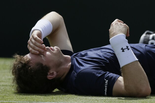 Britain's Andy Murray receives treatment during his doubles match against France's Jo-Wilfried Tsonga and Nicolas Mahut, during the quarterfinal matches of the Davis Cup at the Queen's Club in London, Saturday July 18, 2015. (AP Photo/Tim Ireland)