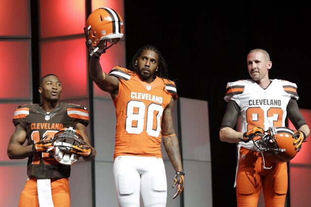 Cleveland Browns' Dwayne Bowe (80)  holds up a helmet as Taylor Gabriel (18), and Brian Hartline (83) watch during the uniform unveiling Tuesday, April 14, 2015, in Cleveland. After two years of planning and months of speculation and secrecy, the Browns unveiled new uniforms they hope will be a big hit with Cleveland fans. (AP Photo/Tony Dejak)