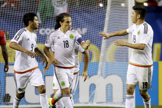 Mexico’s Andres Guardado, center, is congratulated by teammates Jesus Corona, left, and Oribe Peralta after scoring on a penalty kick during the second half of a CONCACAF Gold Cup soccer semifinal against Panama on Wednesday, July 22, 2015, in Atlanta. (AP Photo/David Goldman)