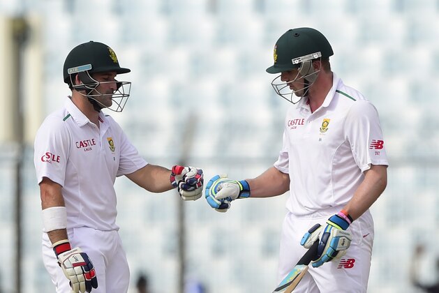 South Africa cricketer Dean Elgar (L) cheers up with his teammate Stiaan van Zyl (R) during the third day of the first cricket Test match between Bangladesh and South Africa at the Zahur Ahmed Chowdhury Stadium in Chittagong on July 23, 2015. AFP PHOTO/ Munir uz ZAMAN        (Photo credit should read MUNIR UZ ZAMAN/AFP/Getty Images)