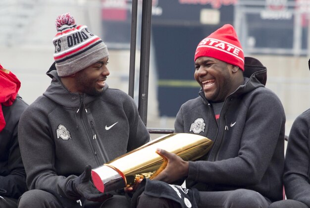 Jan 24, 2015; Columbus, OH, USA; Ohio State Buckeyes quarterback J.T. Barrett (16) hands the National Championship trophy to quarterback Cardale Jones (12) during the National Championship celebration at Ohio Stadium. Mandatory Credit: Greg Bartram-USA TODAY Sports