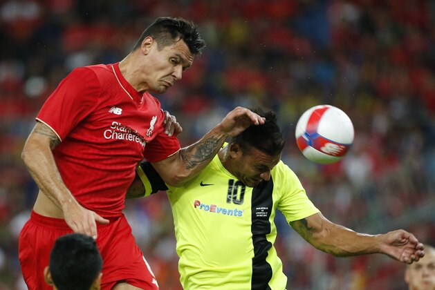 Liverpool's Dejan Lovren, left, fights for the ball with Malaysia's XI Charles Souza Chad during their friendly soccer match in Kuala Lumpur, Malaysia, on Friday, July 24, 2015. (AP Photo/Vincent Thian)