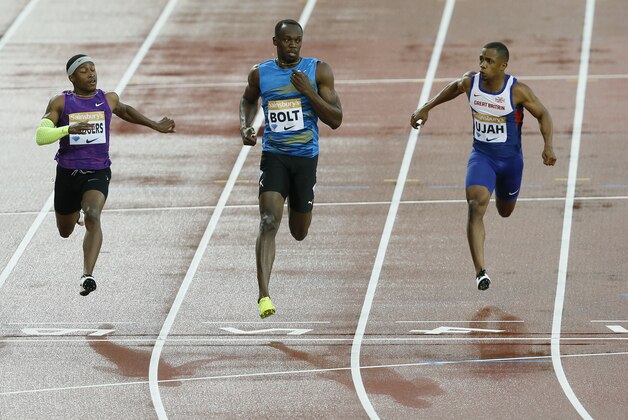 Usain Bolt of Jamaica, centre, wins the second men's 100m heat with Michael Rodgers of USA, left, and Chijindu Ujah of Britain, right, during the Diamond League athletics meeting at the Olympic Stadium in the Queen Elizabeth Olympic Park in London, Friday, July 24, 2015. Many world champion athletes are gathering at London’s Olympic Stadium this weekend for the two-day IAAF Diamond League athletics meeting. (AP Photo/Kirsty Wigglesworth)