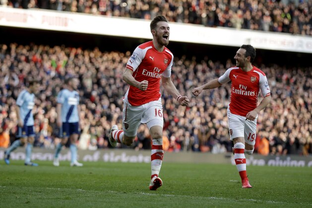 Arsenal's Aaron Ramsey, center, celebrates scoring his side's second goal during the English Premier League soccer match between Arsenal and West Ham United at the Emirates Stadium in London, Saturday, March 14, 2015.  (AP Photo/Matt Dunham)