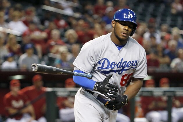 Los Angeles Dodgers' Yasiel Puig tosses his bat away after earning a walk against the Arizona Diamondbacks during the third inning of a baseball game Wednesday, July 1, 2015, in Phoenix. (AP Photo/Ross D. Franklin)
