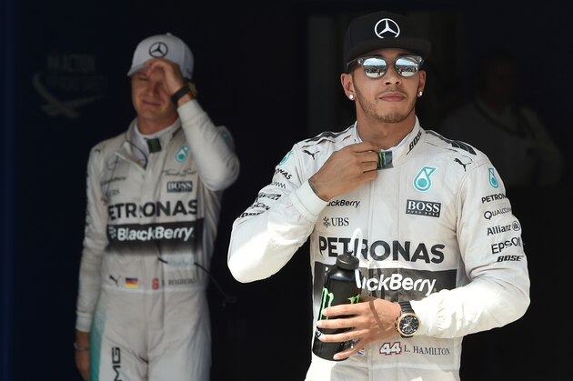Mercedes AMG Petronas F1 Team's German driver Nico Rosberg (L) and Mercedes AMG Petronas F1 Team's British driver Lewis Hamilton react after the qualifying session at the Hungaroring circuit near Budapest on July 25, 2015, on the eve of the Hungarian Formula One Grand Prix. Defending world champion and series leader Lewis Hamilton bidding for a record fifth Hungarian Grand Prix victory will start from pole for Sunday's race after posting the fastest time in qualifying. 
AFP PHOTO / ANDREJ ISAKOVIC        (Photo credit should read ANDREJ ISAKOVIC/AFP/Getty Images)