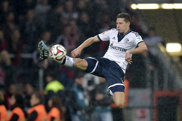 Schalke's Julian Draxler jumps high for the ball during the German Bundesliga soccer match between Bayer Leverkusen and Schalke 04 in Leverkusen,  Germany, Saturday, Oct. 25, 2014. (AP Photo/Martin Meissner)