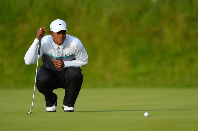 US golfer Tiger Woods lines up a putt on the 18th green during the completion of his second round 75, on day three of the 2015 British Open Golf Championship on The Old Course at St Andrews in Scotland, on July 18, 2015. Tiger Woods missed the cut at the British Open for just the second time in his career at St Andrews on Saturday. He carded a second round of 75 to go with his opening 76 and at seven over he was well outside the cut mark which stood at level par. AFP PHOTO / GLYN KIRK        (Photo credit should read GLYN KIRK/AFP/Getty Images)