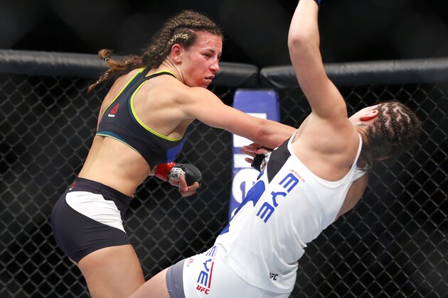 Miesha Tate, left, knocks down Jessica Eye during their women's bantamweight mixed martial arts bout during UFC Chicago on Saturday, July 25, 2015, in Chicago. (AP Photo/Jeff Haynes)