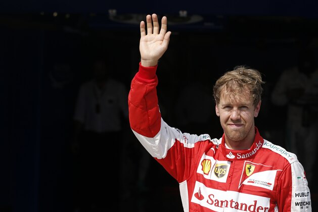 Ferrari driver Sebastian Vettel of Germany greets spectators after placing third in the qualification for the Hungaroring circuit outside Budapest, Hungary, Saturday, July 25, 2015. The Hungarian Formula One Grand Prix will be held on Sunday July, 26. (AP Photo/Darko Vojinovic)