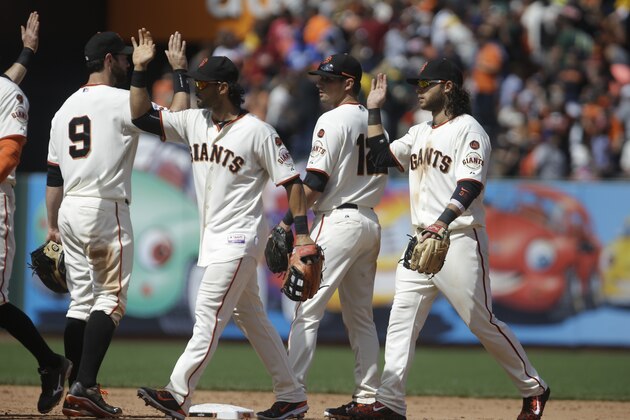 San Francisco Giants celebrate the 2-1 victory over the Oakland Athletics at the end of a baseball game Saturday, July 25, 2015, in San Francisco. (AP Photo/Ben Margot)