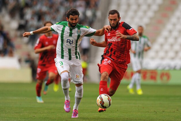 Cordoba's defender Jose Angel Crespo (L) vies with Sevilla's midfielder Aleix Vidal during the Spanish league football match Cordoba CF vs Sevilla FC at El Nuevo Arcangel stadium in Cordoba on September 21, 2014.   AFP PHOTO/ JORGE GUERRERO        (Photo credit should read Jorge Guerrero/AFP/Getty Images)