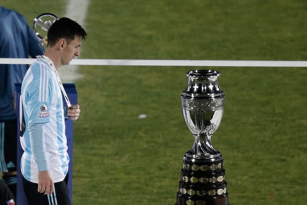 Argentina's Lionel Messi walks next to the Copa America trophy during the Copa America final soccer match at the National Stadium in Santiago, Chile, Saturday, July 4, 2015. (AP Photo/Silvia Izquierdo)