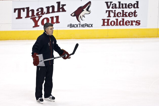 An advertisement shows an appreciation for the fans as Phoenix Coyotes head coach Dave Tippett watches his players during an NHL hockey practice, Tuesday, Jan. 15, 2013, in Glendale, Ariz. (AP Photo/Ross D. Franklin)
