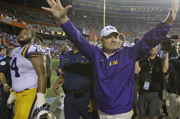 LSU head coach Les Miles waves to fans as he comes off the field after defeating Florida 30-27 in an NCAA college football game in Gainesville, Fla., Saturday, Oct. 11, 2014. (AP Photo/John Raoux)