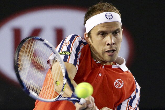 Gilles Muller of Luxembourg makes a backhand return to Novak Djokovic of Serbia during their fourth round match at the Australian Open tennis championship in Melbourne, Australia, Monday, Jan. 26, 2015. (AP Photo/Rob Griffith)