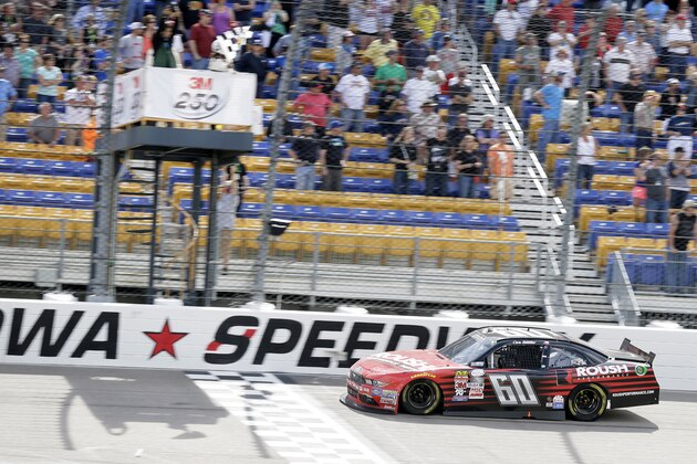 Chris Buescher crosses the finish line as he wins the NASCAR Xfinity Series auto race, Sunday, May 17, 2015, at Iowa Speedway in Newton, Iowa. (AP Photo/Charlie Neibergall)