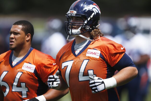 Denver Broncos rookie offenisve tackle Ty Sambrailo, front, runs on the field with offensive guard Shelley Smith to take part in an organized training activity at the NFL football team's headquarters in Englewood, Colo., Monday, June 1, 2015. (AP Photo/David Zalubowski)
