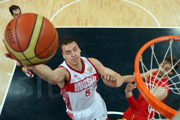 Russia's centre Alexander 'Sasha' Kaun jumps to score past Spain's forward Pau Gasol (R) during their London 2012 Olympic Games men's preliminary round group B basketball match in London on August 4, 2012. AFP PHOTO/POOL/CHRISTIAN PETERSEN        (Photo credit should read Christian Petersen/AFP/GettyImages)