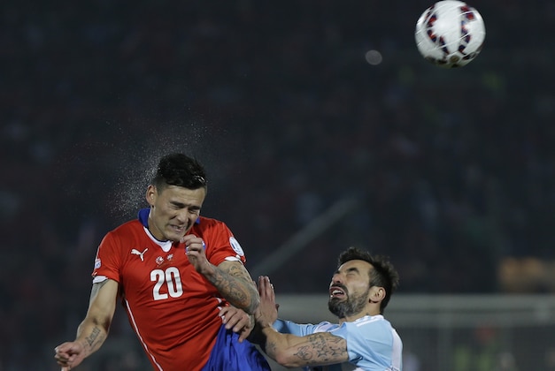 Chile's Charles Aranguiz  and Argentina's Ezequiel Lavezzi go for a header  during the extra time of the Copa America final soccer match between Argentina and Chile at the National Stadium in Santiago, Chile, Saturday, July 4, 2015. (AP Photo/Natacha Pisarenko)