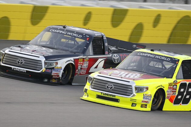 NASCAR drivers Erik Jones (4) and Matt Crafton (88) race side-by-side during a Truck Series auto race at Kansas Speedway in Kansas City, Kan., Friday, May 8, 2015. (AP Photo/Colin E. Braley)