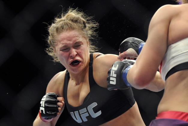 FILE - In this Dec. 28, 2013, file photo, Ronda Rousey, left, of Venice, Calif., punches Miesha Tate of Yakima, Wash., during the UFC 168 mixed martial arts women's bantamweight title fight in Las Vegas. Rousey won by a third round tap out. Rousey has dominated every challenger in her two-year reign as the UFC's only women's bantamweight champion. Cat Zingano still believes she has a legitimate shot at Rousey's belt in UFC 184 on Saturday, Feb. 28, 2015, in Los Angeles. (AP Photo/David Becker, File)