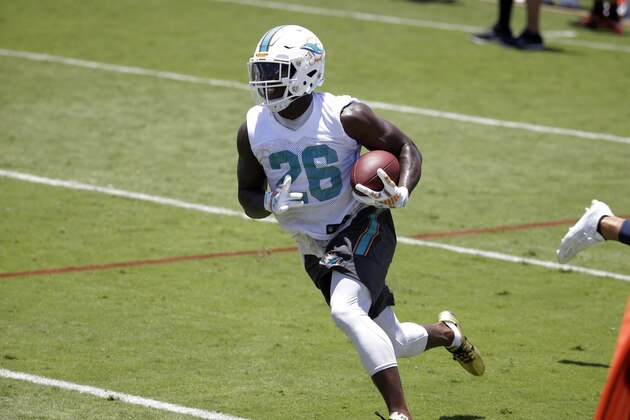 Miami Dolphins running back Lamar Miller (26) runs with the football during an NFL football organized team activity, Monday, June 1, 2015, in Davie, Fla. (AP Photo/Lynne Sladky)