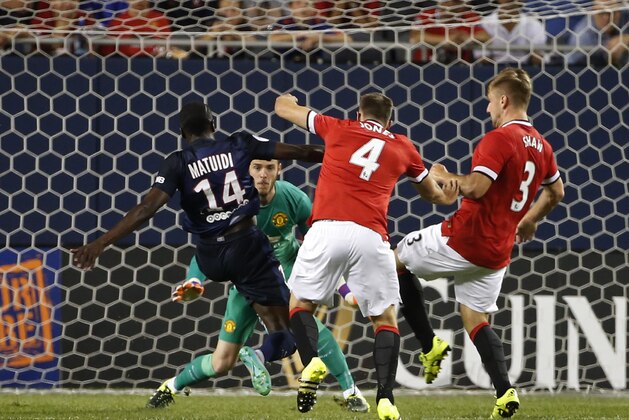 Paris Saint-Germain midfielder Blaise Matuidi (14) scores against Manchester United goalkeeper David De Gea, back, defender Phil Jones (4) and defender Luke Shaw (3) in the first half of an International Champions Cup soccer match on Wednesday, July 29, 2015, in Chicago. (AP Photo/Kamil Krzaczynski)