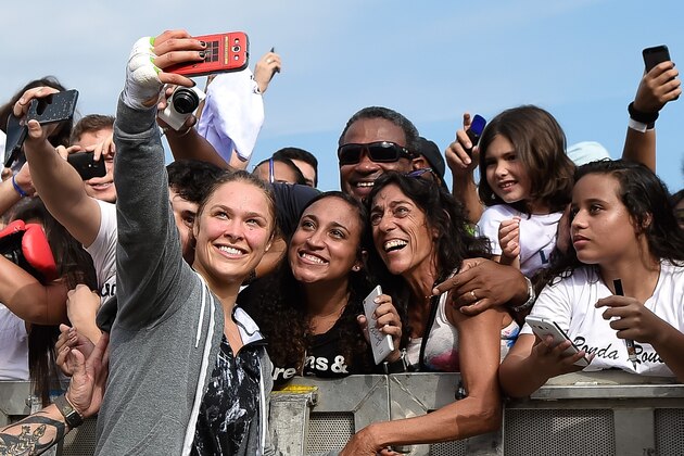 RIO DE JANEIRO, BRAZIL - JULY 29:  Womens bantamweight champion Ronda Rousey of the United States takes photos with fans during open training session at Pepe Beach on July 29, 2015 in Rio de Janeiro, Brazil.  (Photo by Buda Mendes/Zuffa LLC/Zuffa LLC via Getty Images)