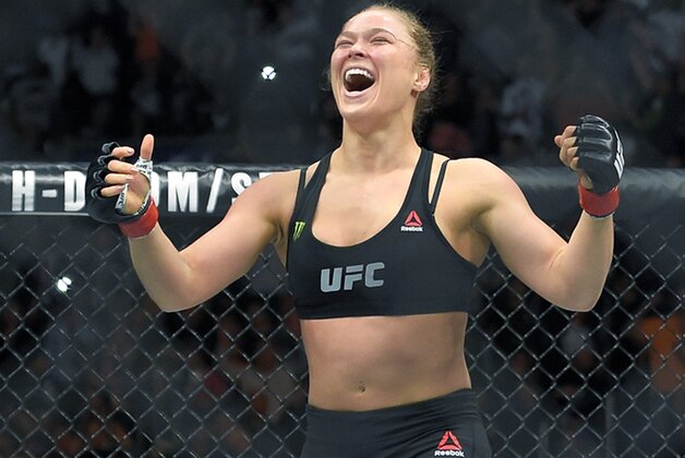 FILE - In this Feb. 28, 2015 file photo, Ronda Rousey, with Reebok insignia on her uniform, celebrates after defeating Cat Zingano in a UFC 184 mixed martial arts bantamweight title bout in Los Angeles. UFC fighters will be paid for wearing Reebok gear based on their tenure in the octagon under the mixed martial arts promotion’s new sponsorship deal. The UFC on Wednesday, May 6, 2015, announced the change in its pay structure for its deal with Reebok, which signed on late last year to outfit every fighter. (AP Photo/Mark J. Terrill, File)
