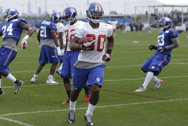 New York Giants wide receiver Victor Cruz, second from right, runs a ball into the end zone during a NFL football camp in East Rutherford, N.J., Thursday, July 24, 2014. (AP Photo/Seth Wenig)