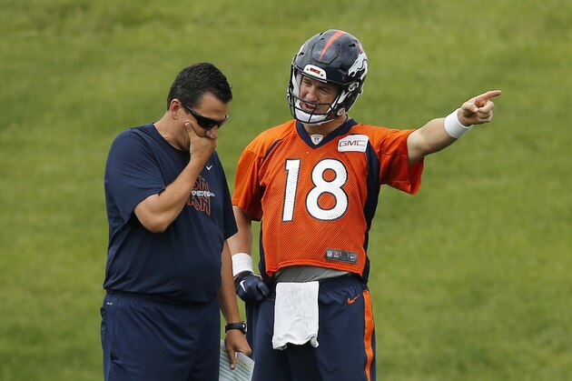Denver Broncos quarterback Peyton Manning, right, talks with quarterback coach Greg Knapp during an NFL football organized team activity, Monday, June 15, 2015, in Englewood, Colo. (AP Photo/Jack Dempsey)