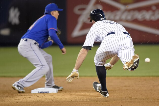 New York Mets shortstop Wilmer Flores, right, waits for the ball to tag out New York Yankees' Brett Gardner attempting to stretch a single into a double  during the third inning of an interleague baseball game Friday, April 24, 2015, at Yankee Stadium in New York. (AP Photo/Bill Kostroun)