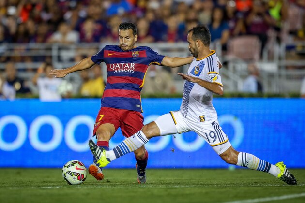 FC Barcelona's Pedro Rodriguez tries to keep ahead of Los Angeles Galaxy's AJ De La Garza during Tuesday's soccer match at the Rose Bowl in Pasadena, Calif., Tuesday, July 21, 2015. (Doug Benc/AP Images for International Champions Cup)